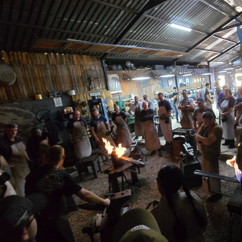 Black Dragon Forge Bladesmithing Experience  - Group of people gathered in a rustic indoor setting with wooden walls and a bar area.