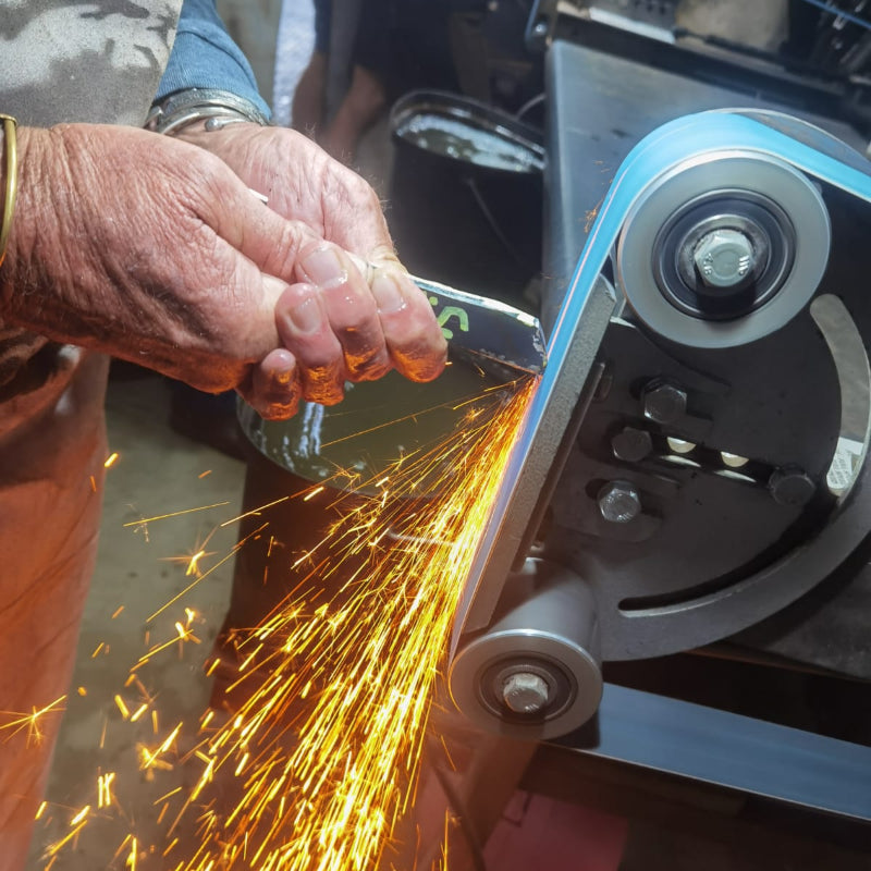 Person using a grinder with sparks flying, likely in a workshop setting.