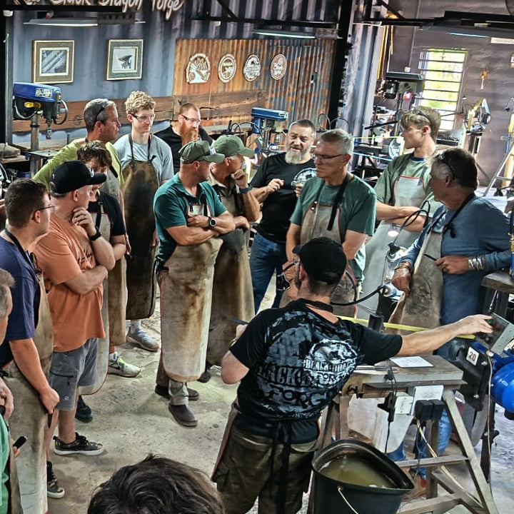 Group of people in a workshop setting with tools and equipment.