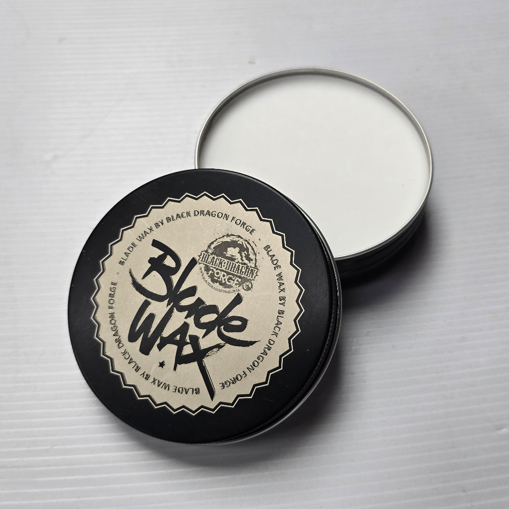 Black and white container of Blade Wax on a gray background