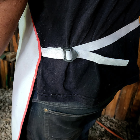 Close-up of a person wearing a black apron with a reflective white stripe.