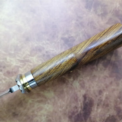 Wooden-handled knife with metal blade on a textured surface