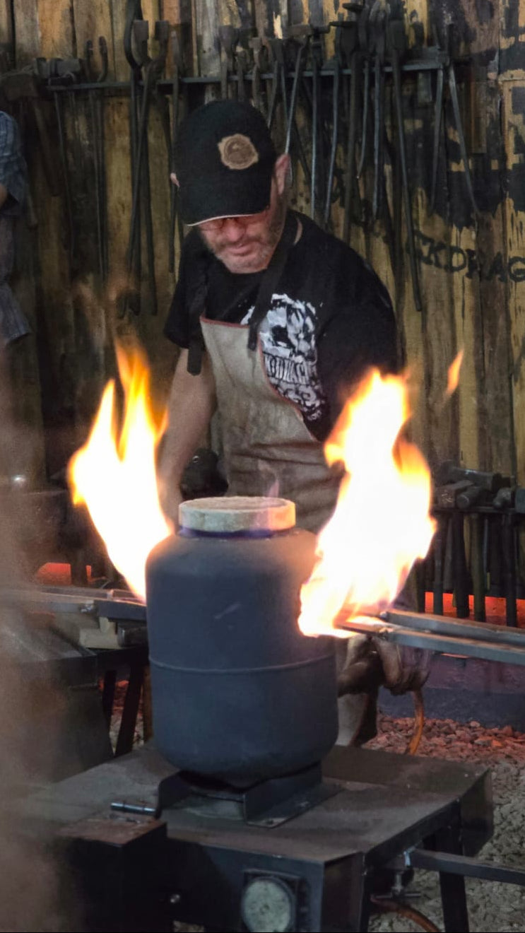 Person working with flames and metal tools in a workshop setting