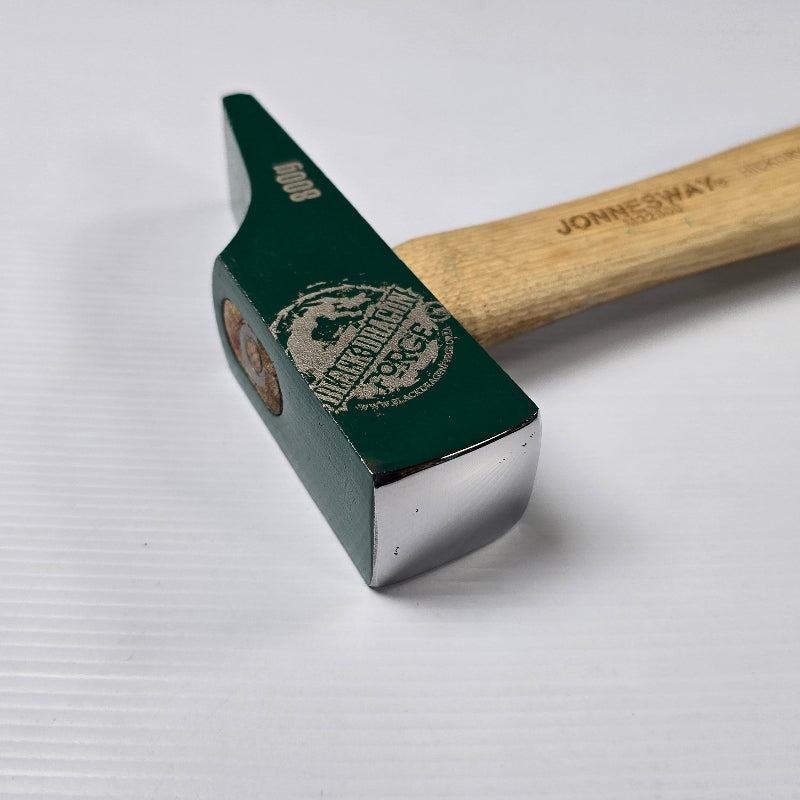 Hammer with a green head and wooden handle on a white background
