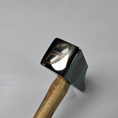 Small hammer with a metallic head and wooden handle on a gray background