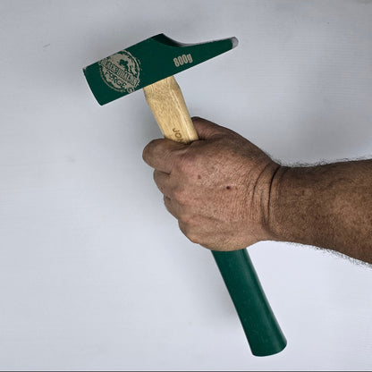 Hand holding a green hammer with wooden handle on a white background